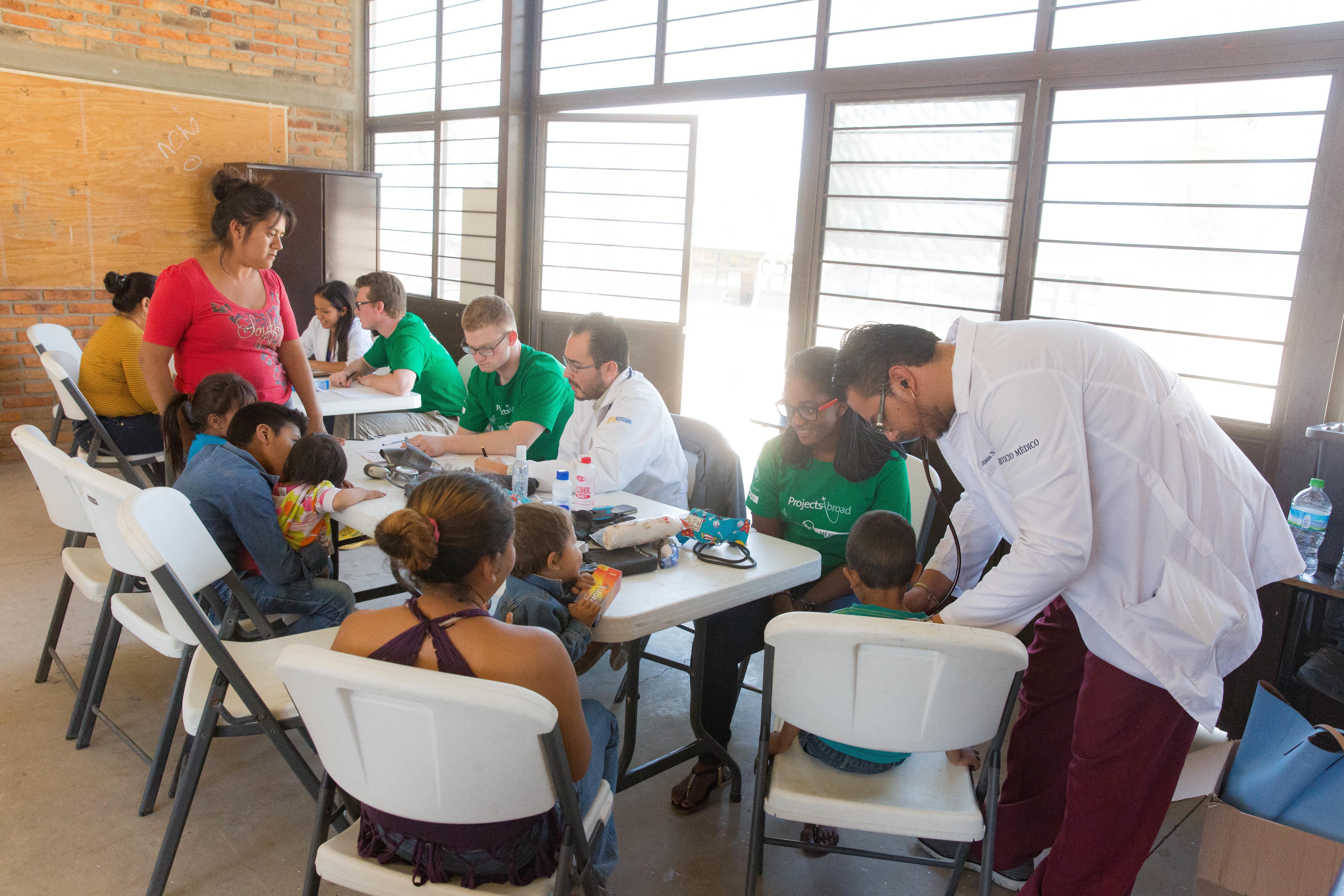 Children and parents are assisted during an outreach by students and medical staff, on the Public Health Internship for teenagers in Mexico. Students at their Public Health placement for teenagers in Mexico, learn how to take vital signs during an outreach.